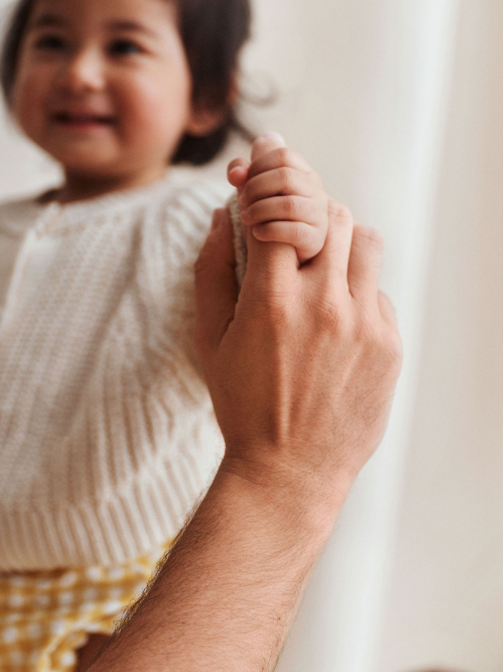 Child holding an adult's finger
