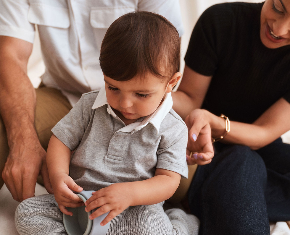 A child with his parents smiling behind him