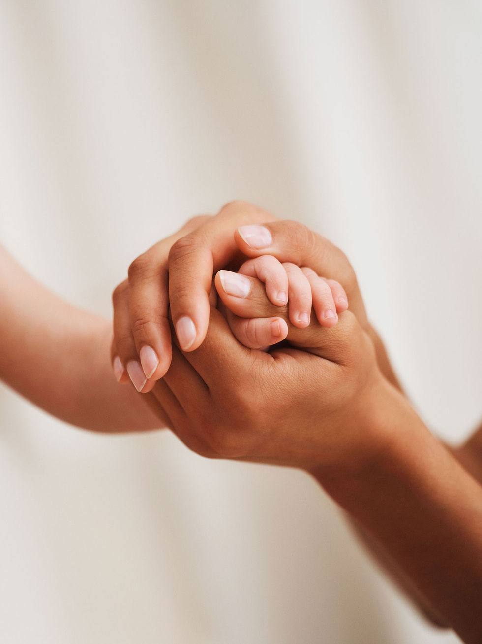Woman holding the tiny hands of a baby
