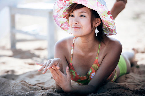 A woman lying on the sand of a beach