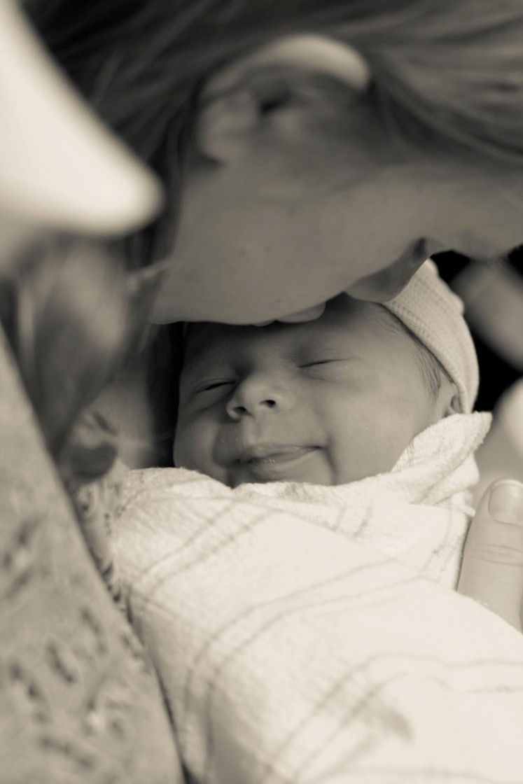 Newborn baby being held by its mother