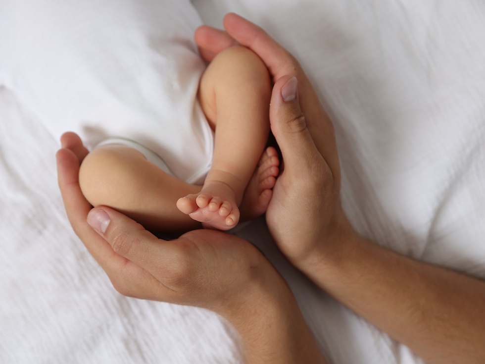 A newborn baby be held by a woman